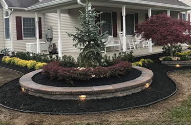 Weed removal, plant trimming, fresh mulch, new trees and flowers now grace the space, breathing life into the surroundings.